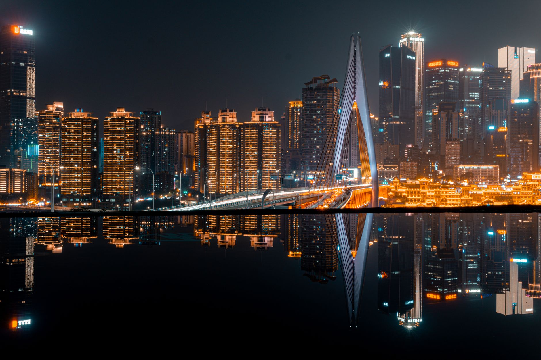illuminated skyline of a city reflecting in the water